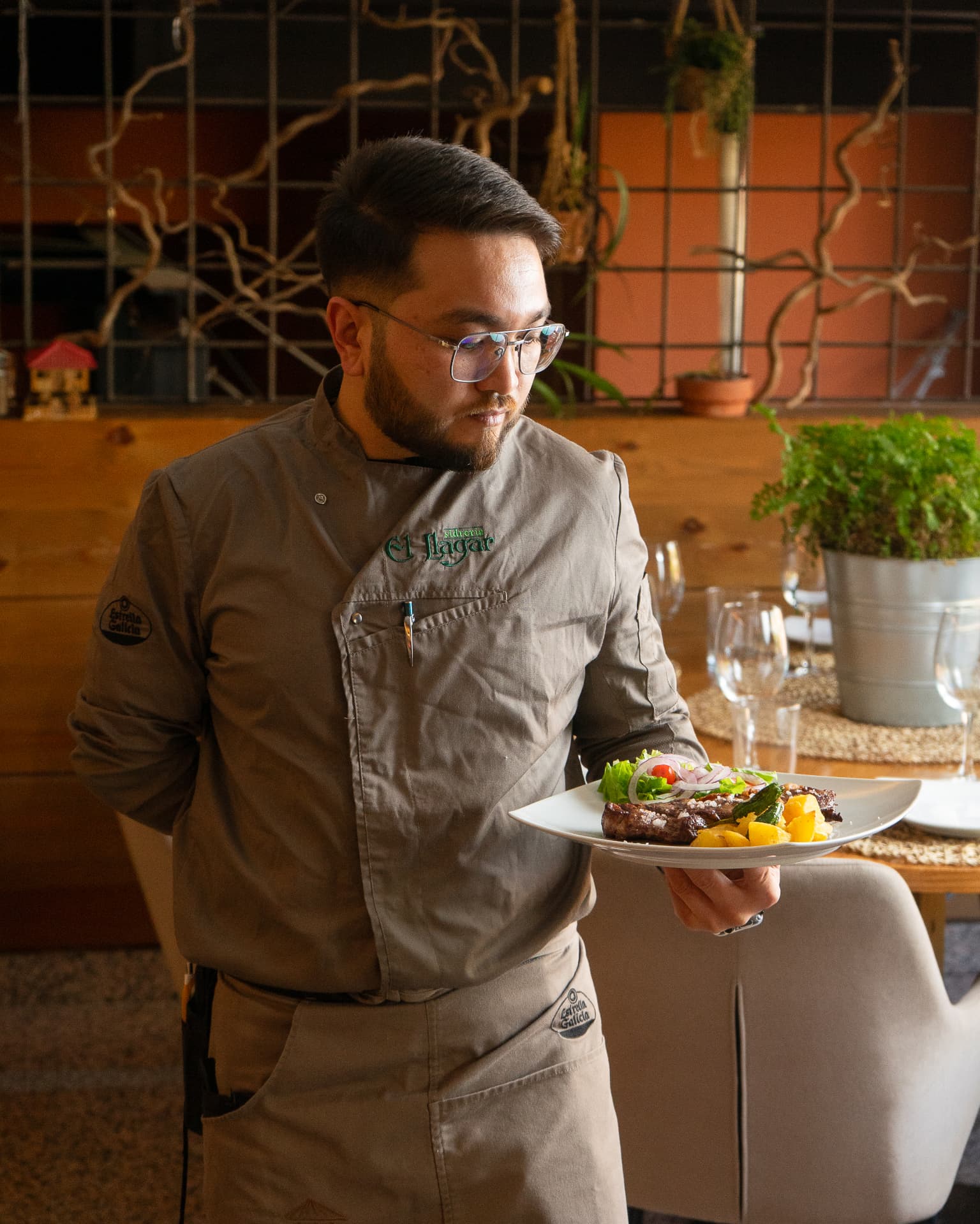 Cocinero llevando un plato en la sala del restaurante