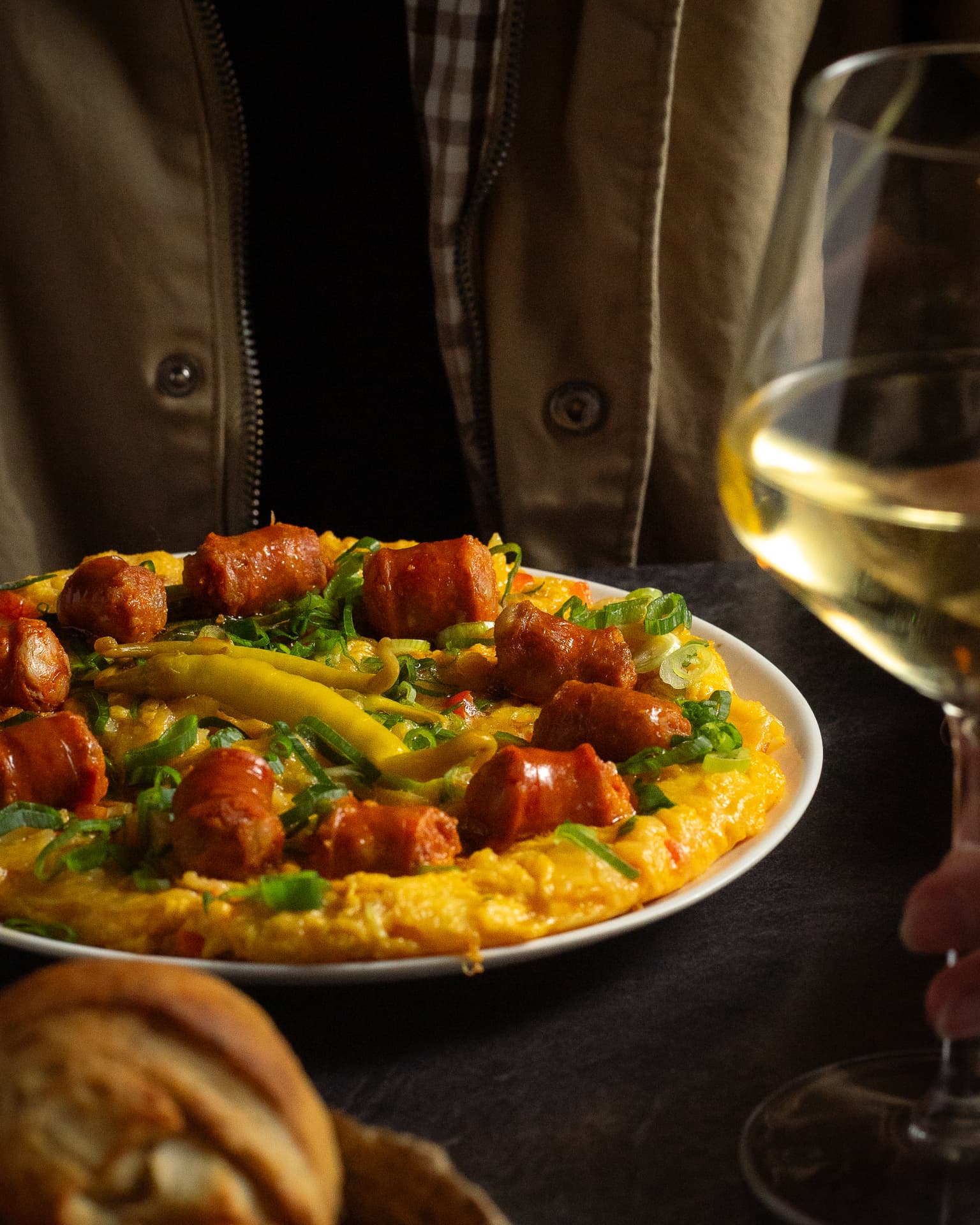 Arroz con chorizo y cebolleta junto a una copa de vino blanco
