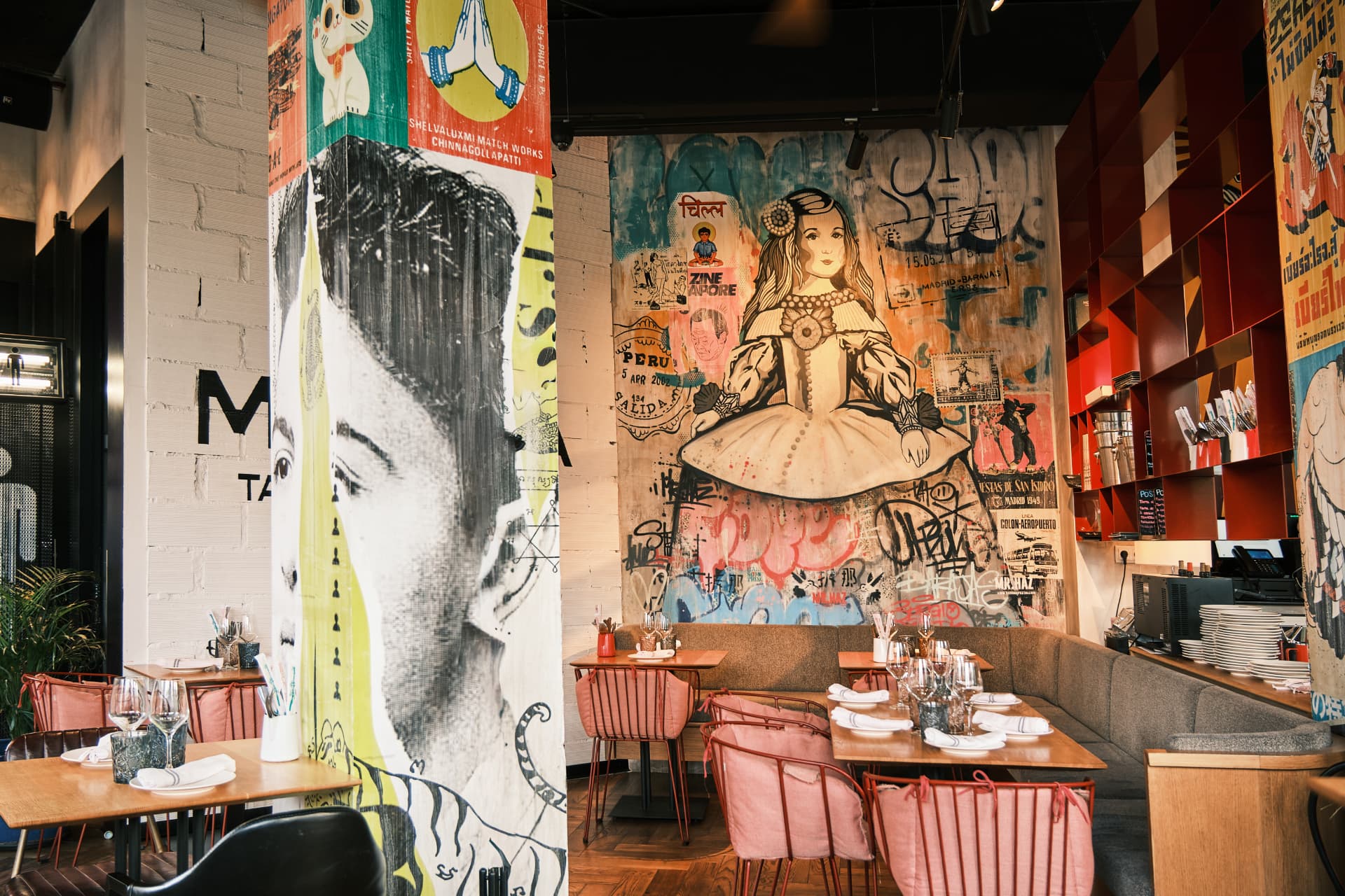 Sala del restaurante con murales y mesas preparadas