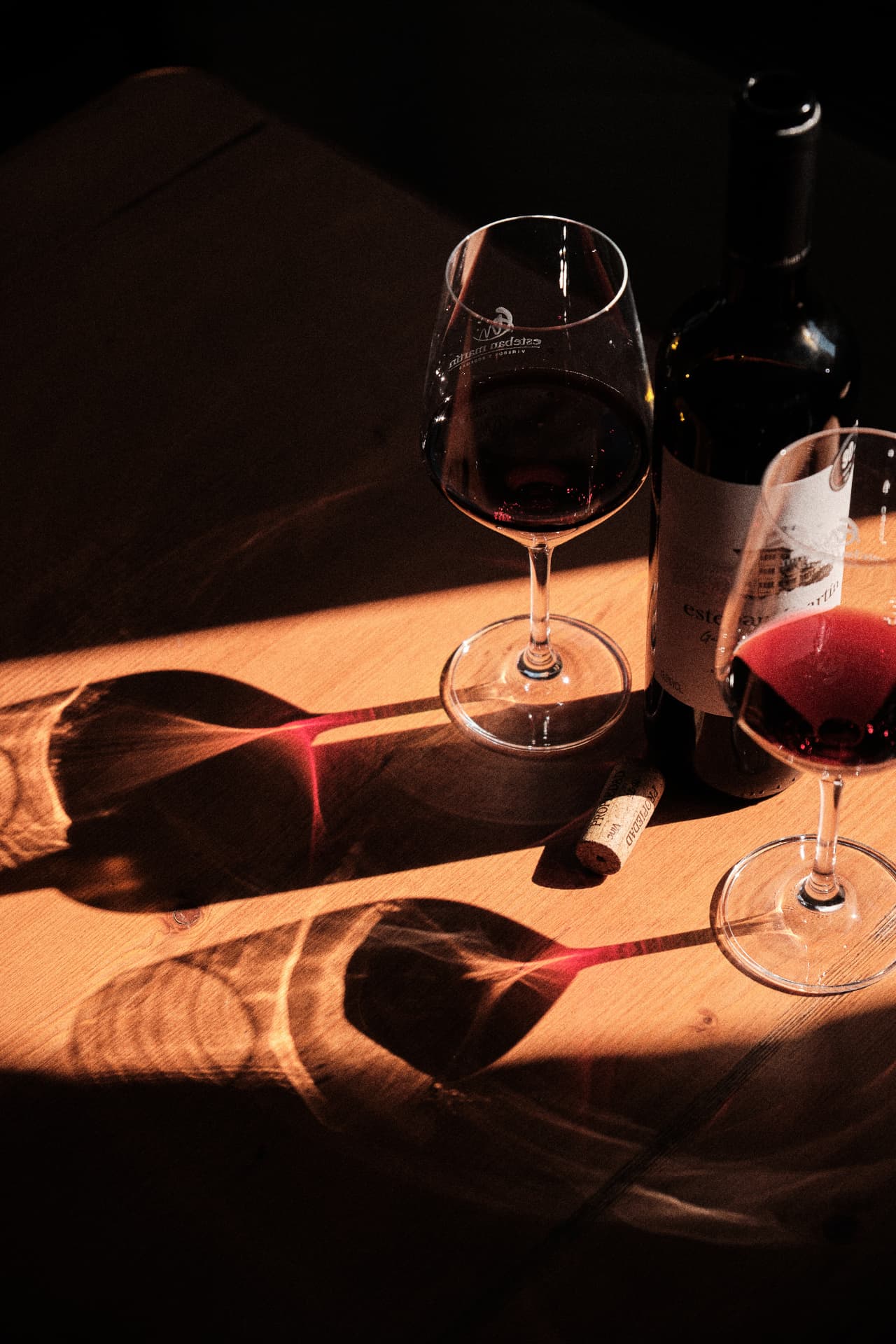 Botella y copas de vino sobre una mesa de madera