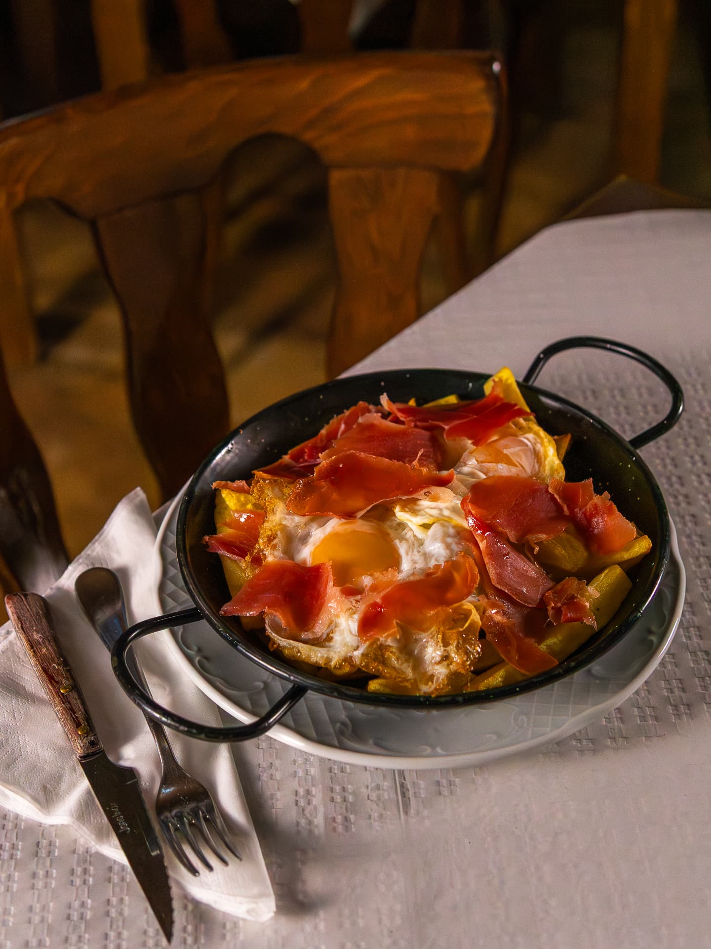 Cazuela de patatas con huevos y jamón sobre la mesa
