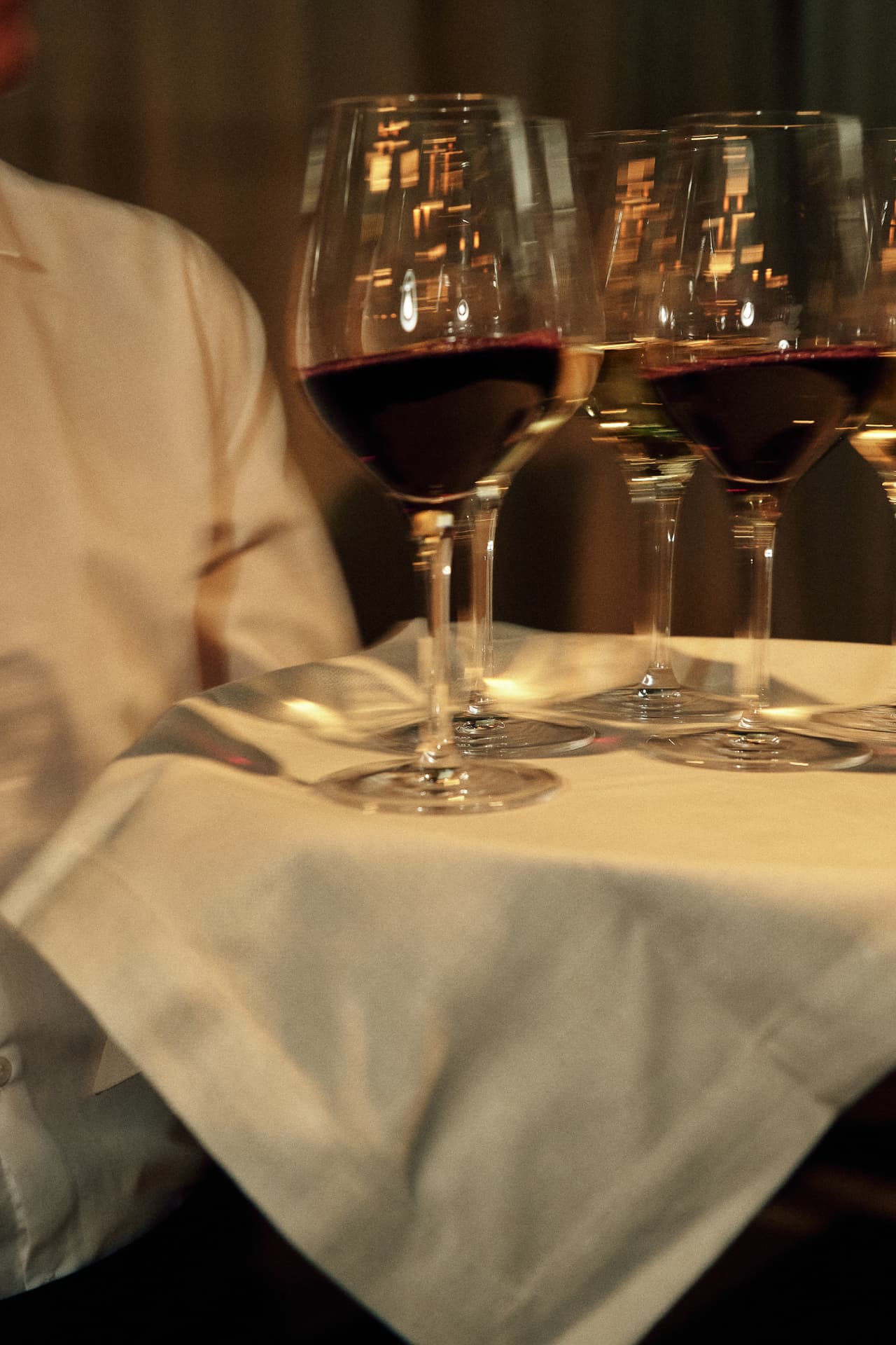 Camarero llevando una bandeja con copas de vino