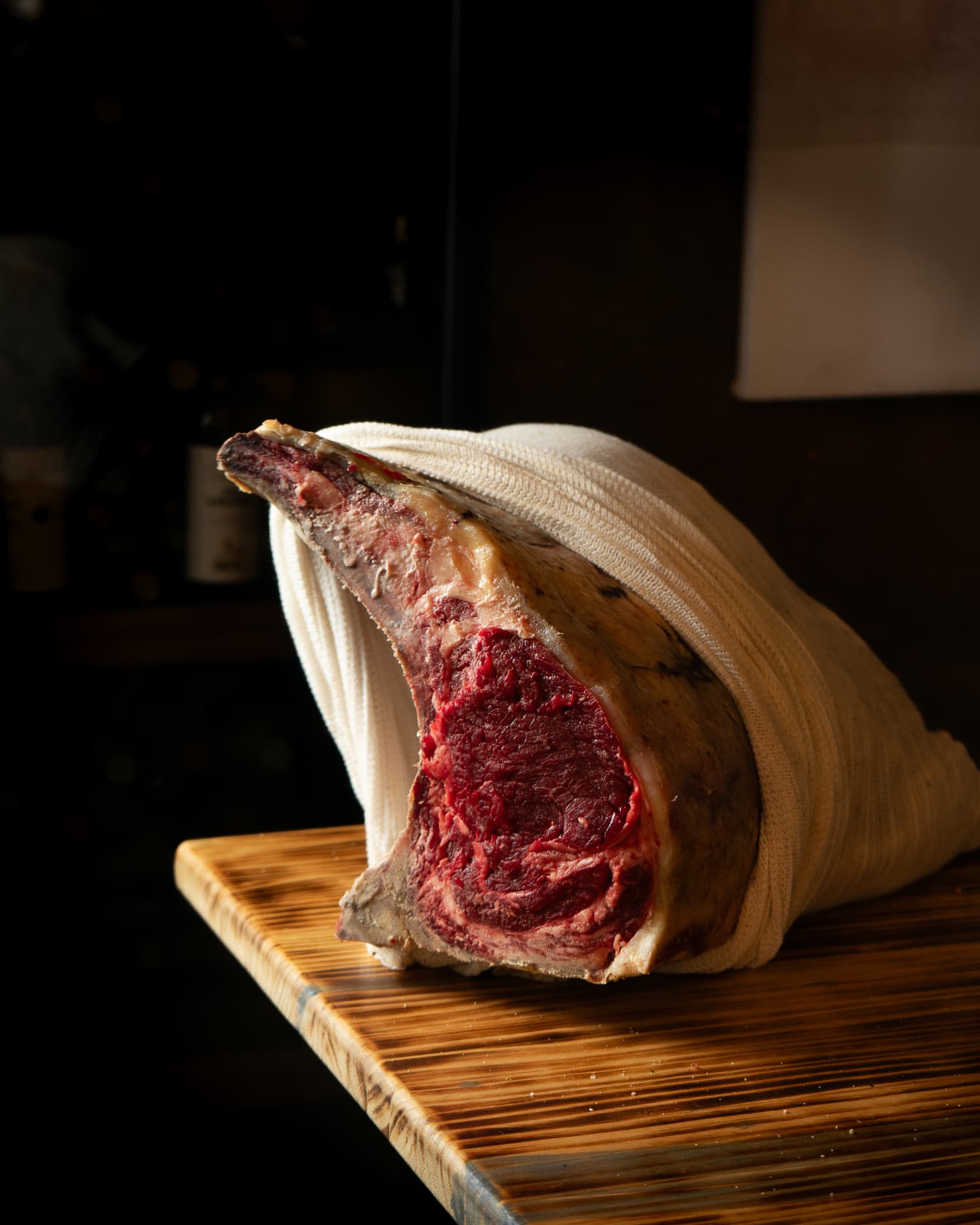 Chuletón envuelto en tela sobre una tabla de madera