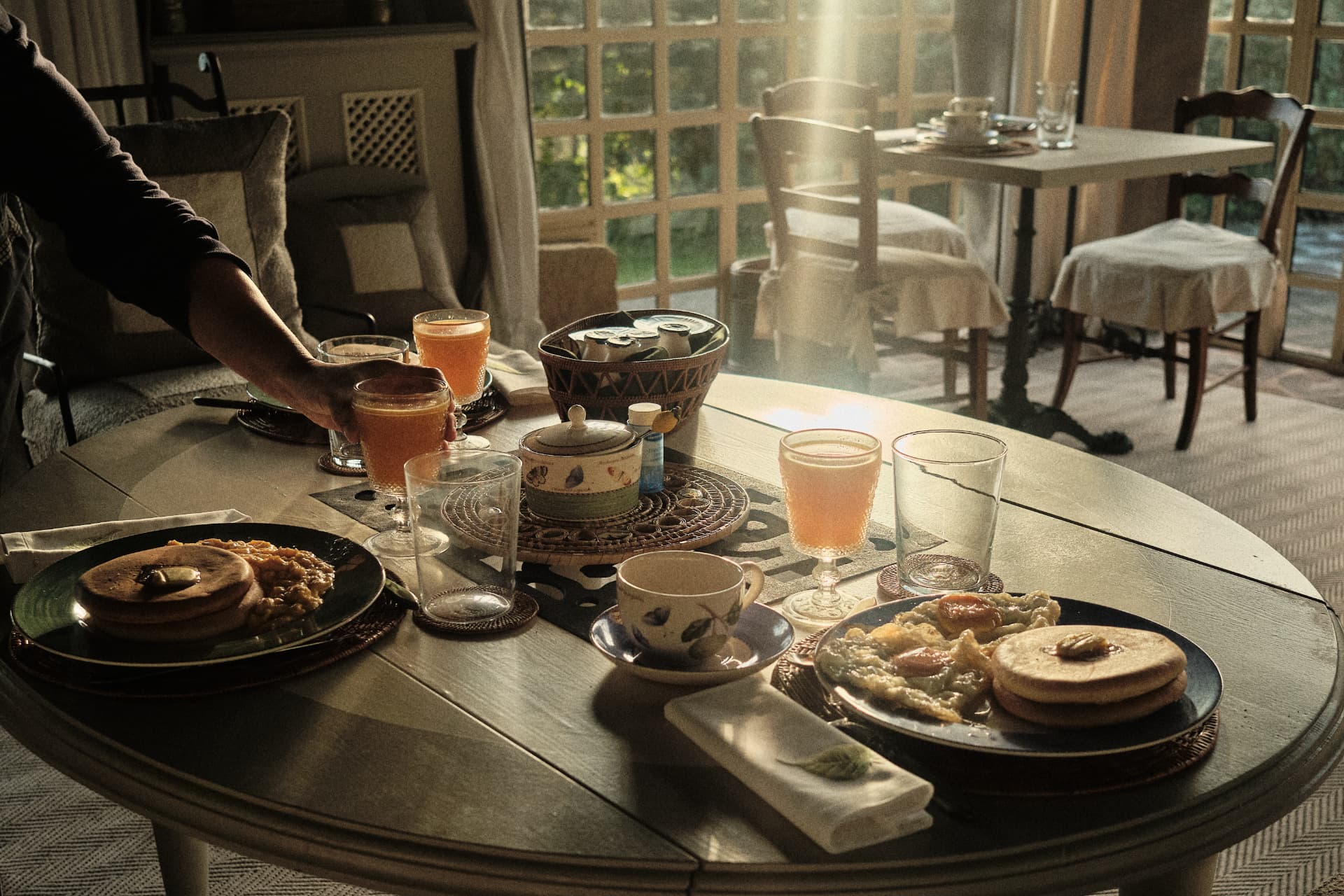 Desayuno servido sobre una mesa junto a la ventana