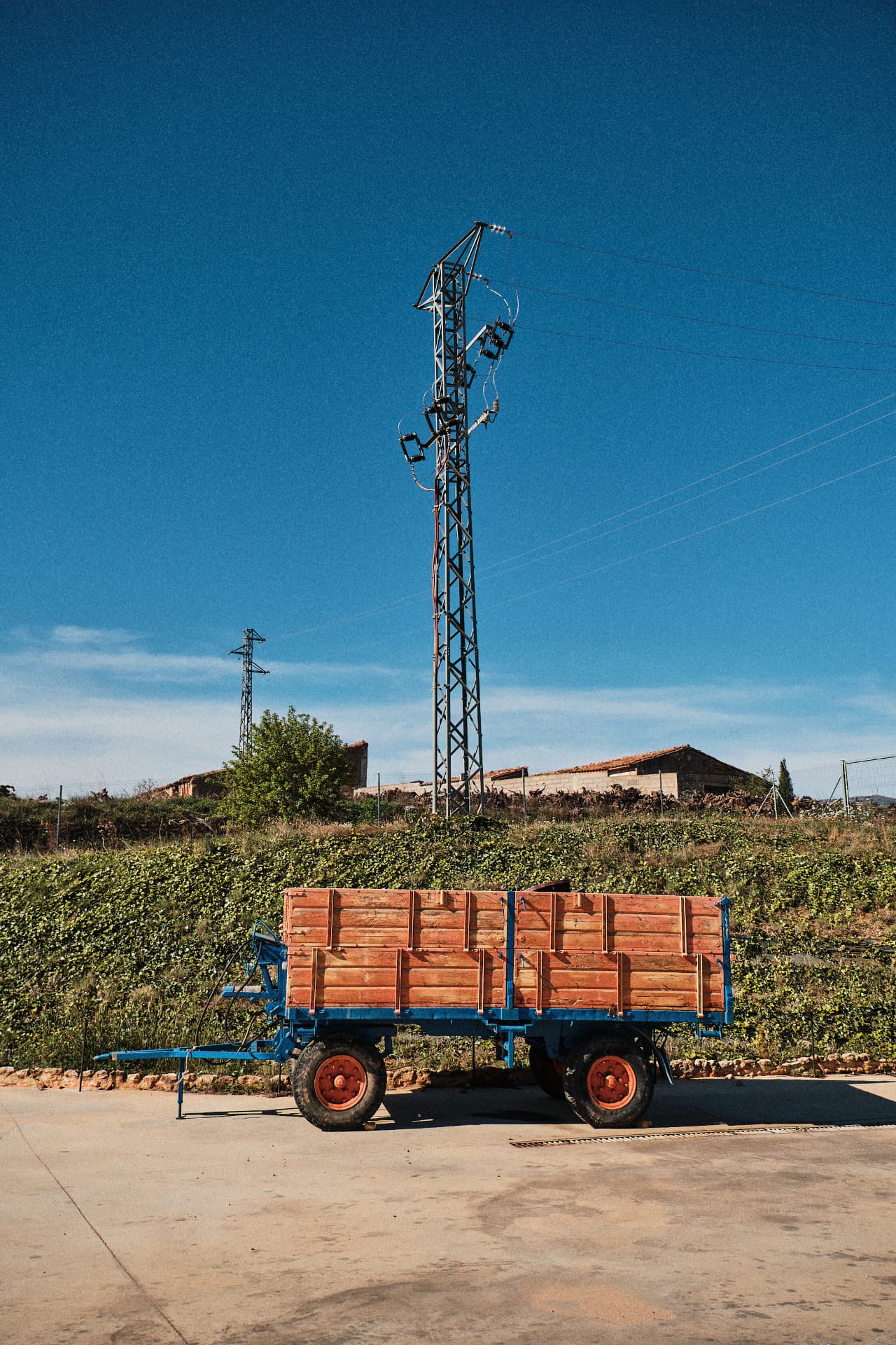 Remolque azul de madera aparcado junto a la viña