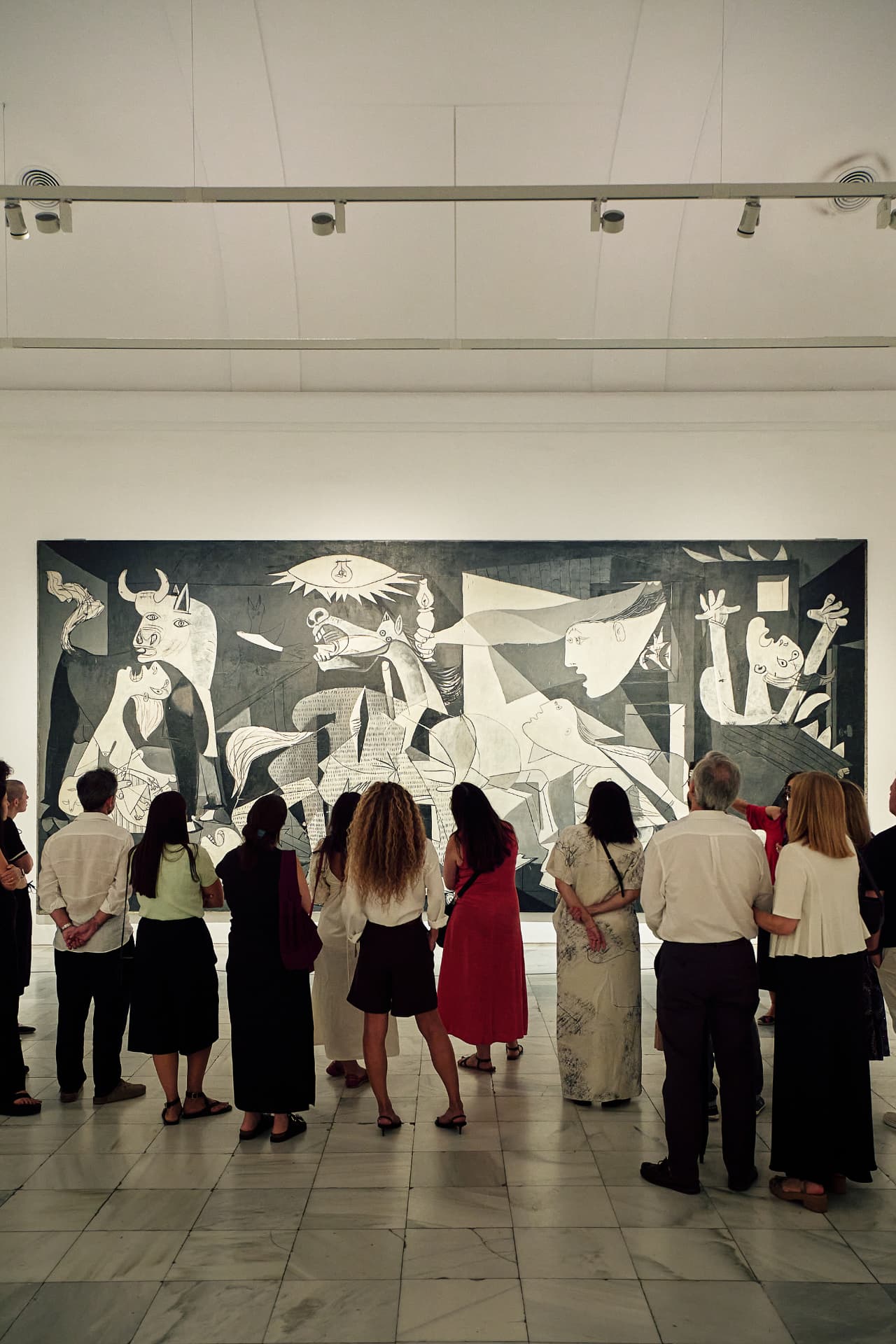 Grupo de personas contemplando un gran cuadro en un museo